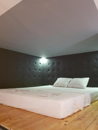 a bedroom with a large white bed with a wall at Apartman Lena Loft - best value, best choice! in Osijek