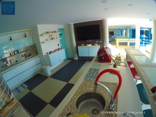 a living room with a tv and a checkerboard floor at Residência Angra Deep Blue in Angra dos Reis
