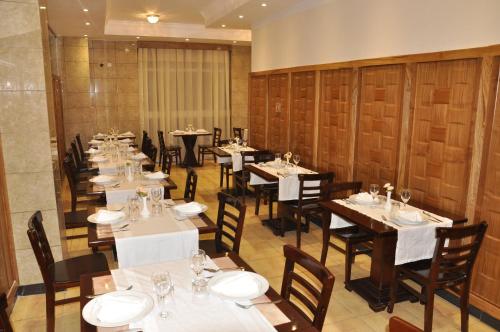a dining room with tables and chairs with white tablecloths at Mekelle Hotel in Mekʼelē