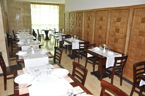a dining room with tables and chairs with white tablecloths at Mekelle Hotel in Mekʼelē