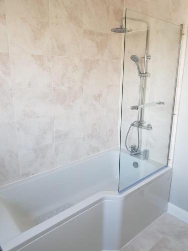 a shower with a glass door in a bathroom at Spire View Townhouse in Ballycastle