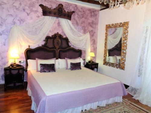 a bedroom with a large bed and a mirror at Hotel Boutique Nueve Leyendas in Úbeda