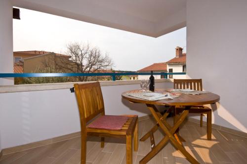 a table and chair on a balcony with a view at Rooms and Apartments Villa Dama in Pula