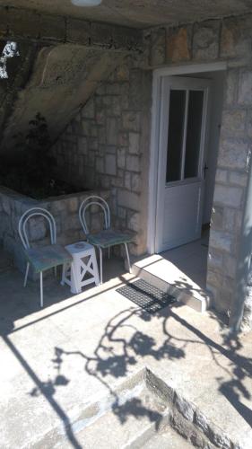 a patio with two chairs and a door and a table at Studio apartman Jakšić in Trebinje