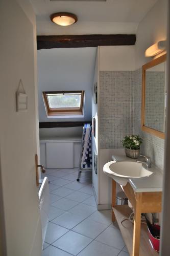 une salle de bain avec un lavabo blanc et une fenêtre dans l'établissement Belle étape Honfleuraise, à Honfleur