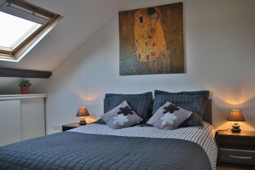 Un dormitorio con una cama azul con una pintura en la pared en Belle étape Honfleuraise, en Honfleur