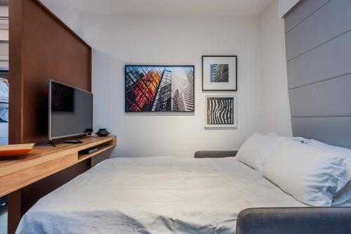 1 dormitorio con 1 cama y escritorio con TV en BHomy Jardins Moderno a 100m Av Paulista AD604, en São Paulo