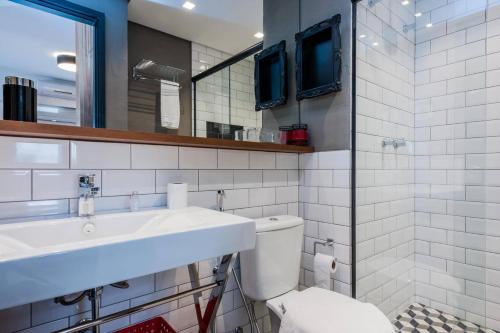een badkamer met een wastafel, een toilet en een spiegel bij BHomy Jardins Moderno a 100m Av Paulista AD604 in Sao Paulo