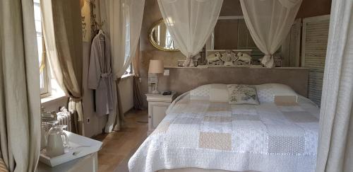 a bedroom with a white bed and a mirror at Le jardin de Saint Jean in Saint-Jean-aux-Bois