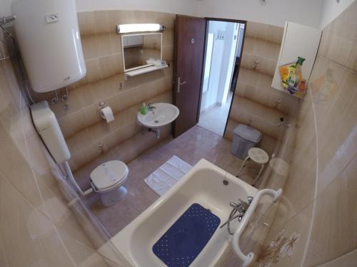 uma casa de banho com uma banheira, um WC e um lavatório. em Apartment A. Žižić em Slatine