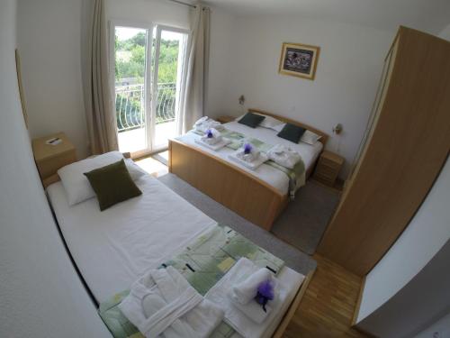 Habitación con vistas a un dormitorio con 2 camas y ventana. en Apartment A. Žižić en Slatine