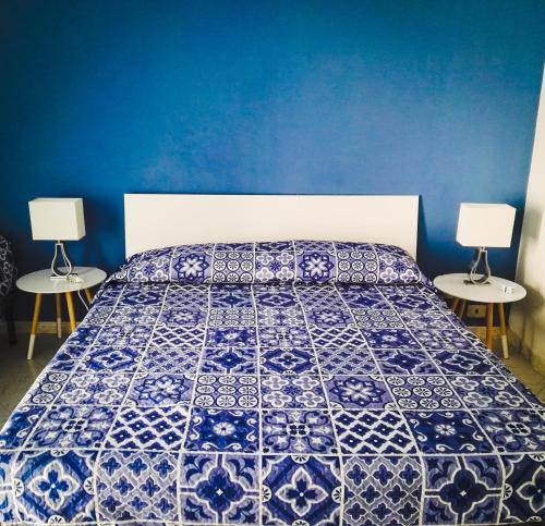 ナポリにあるBorgo di San Gennaroのベッドルーム1室(青と白のベッド1台、テーブル2台付)