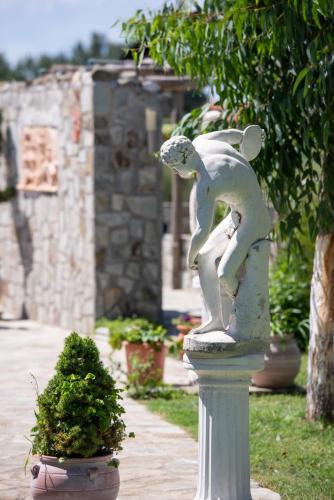 a statue of a person on a pedestal in a garden at Caretta Village in Toroni