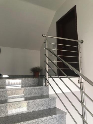 a staircase with a metal railing and a door at Apartment & Rooms Thomas in Korenica
