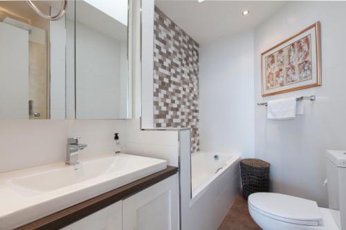 een witte badkamer met een wastafel en een toilet bij New Cumberland 501 by CTHA in Kaapstad
