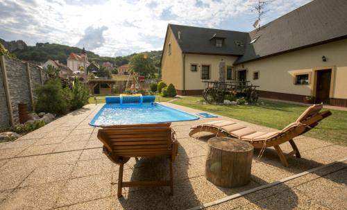 a backyard with a swimming pool and two chairs at Penzion Živá Pálava in Klentnice