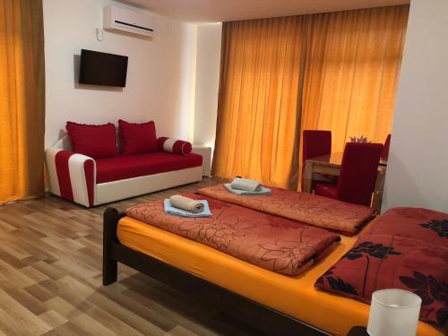 una camera d'albergo con due letti e un divano di Apartment & Rooms Thomas a Korenica
