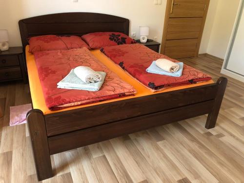 two beds with red sheets and white towels on them at Apartment & Rooms Thomas in Korenica