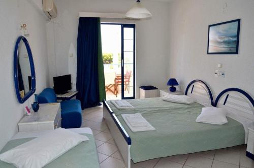 a hotel room with two beds and a balcony at Anna Studios in Agia Marina Aegina