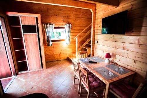 a dining room with a table in a wooden cabin at Domki Heaven Ustronie Morskie in Ustronie Morskie