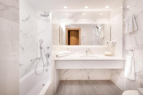 een witte badkamer met een wastafel en een douche bij Horizon Beach Resort in Mastichari