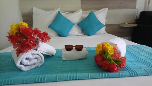 a bedroom with a bed with towels and flowers on it at Appart de Charme Res Archipel & Savane in Le Gosier