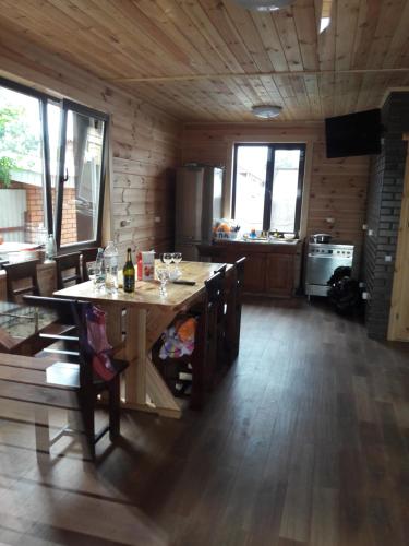 a kitchen with a table in a wooden cabin at Шале Озера in Melʼniki