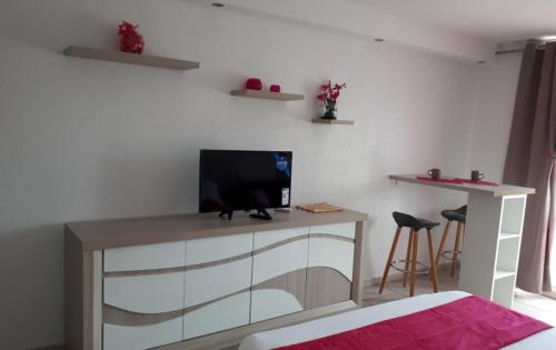una camera con scrivania e televisore di Appart de Charme Res Archipel & Savane a Le Gosier
