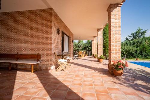 an outdoor patio with a bench and a pool at Villa Marín Toledo in Las Nieves