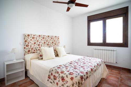 a bedroom with a bed and a ceiling fan at Villa Marín Toledo in Las Nieves