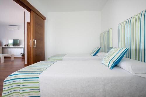 a bedroom with a large bed with blue and white pillows at Villa Marín Toledo in Las Nieves