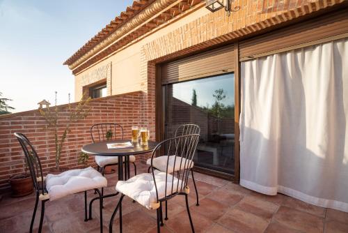 a patio with a table and chairs and a window at Villa Marín Toledo in Las Nieves