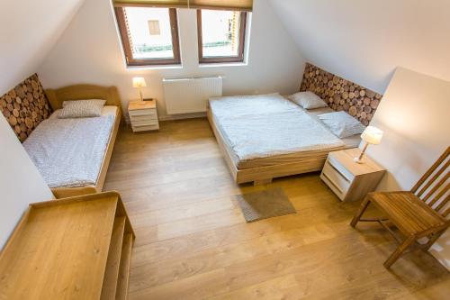 2 łóżka w małym pokoju z 2 oknami w obiekcie VIVAZA Villa Szigliget w mieście Szigliget