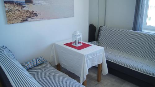 uma mesa com um copo ao lado de duas cadeiras em Apartment Sunny Day Gdynia Center em Gdynia