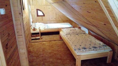 JunoszynoにあるApartamenty Pod Lipamiの木造キャビン内のベッドルーム1室(ベッド2台付)