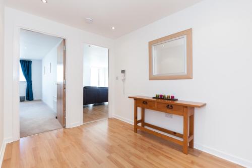 a living room with a table and a mirror at Stylish Garden View Apartment in Edinburgh
