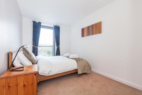 a bedroom with a bed and a window at Stylish Garden View Apartment in Edinburgh