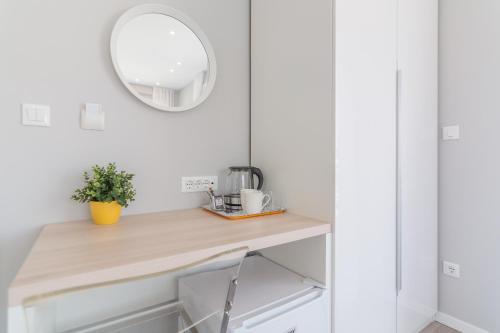 a white kitchen with a wooden counter and a mirror at 4 Elements Old Town Views Rooms in Trogir