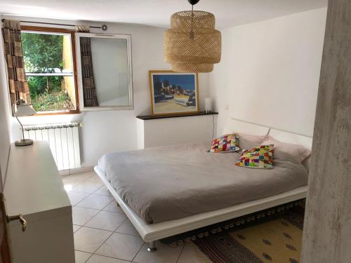 een slaapkamer met een bed met 2 kussens en een raam bij Joli rez-de-villa 80 m2 proche mer in Carqueiranne