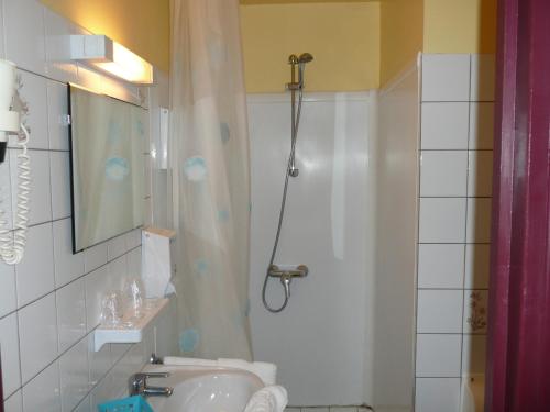 a bathroom with a shower and a sink at Hôtel Restaurant du Pont Vieux in Camarès