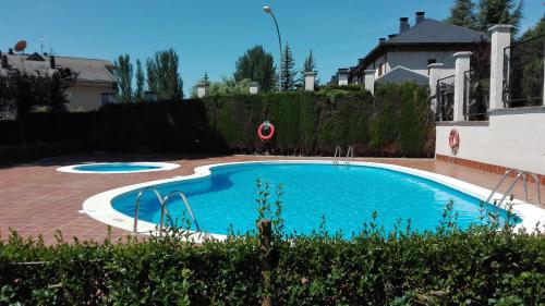 een groot zwembad in een tuin met een huis bij La terraza del Sauce in Jaca