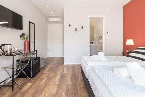 a white bedroom with two beds and a table at 4 Elements Old Town Views Rooms in Trogir