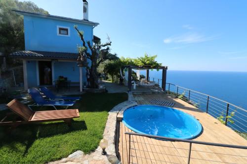 a house with a swimming pool next to the ocean at Fakistra's Blue House in Tsagarada