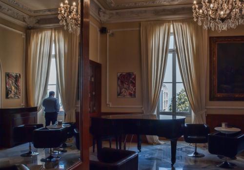a man standing in a room with a table and chairs at Grand Hotel & des Anglais Spa in Sanremo