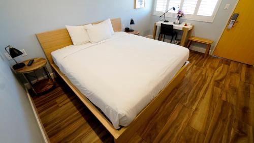 a large bed in a room with a wooden floor at El Royale Gardens Near Universal Studios in Los Angeles