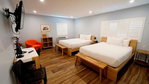 sypialnia z 2 łóżkami, stołem i biurkiem w obiekcie El Royale Gardens Near Universal Studios w Los Angeles