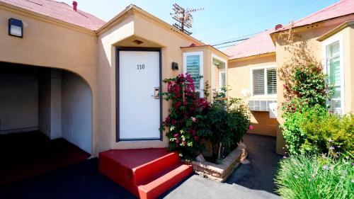 a house with a red door and some flowers at El Royale Hotel - Near Universal Studios Hollywood in Los Angeles