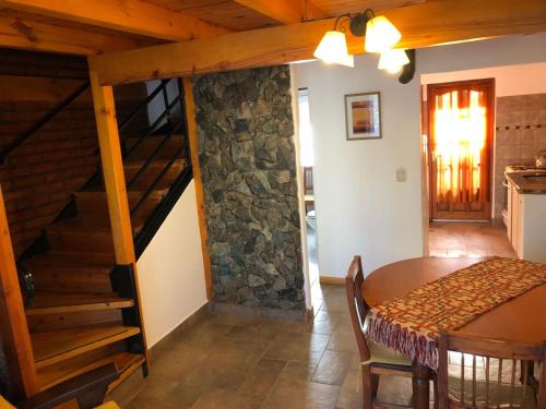 a living room with a staircase and a table and a kitchen at cabanas las moras in El Bolsón