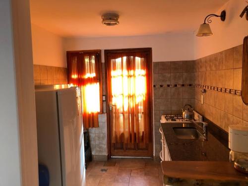 a kitchen with a sink and a refrigerator at cabanas las moras in El Bolsón