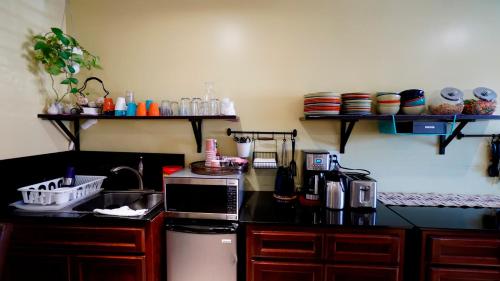 a kitchen with a counter with a sink and a microwave at El Royale Hotel - Near Universal Studios Hollywood in Los Angeles
